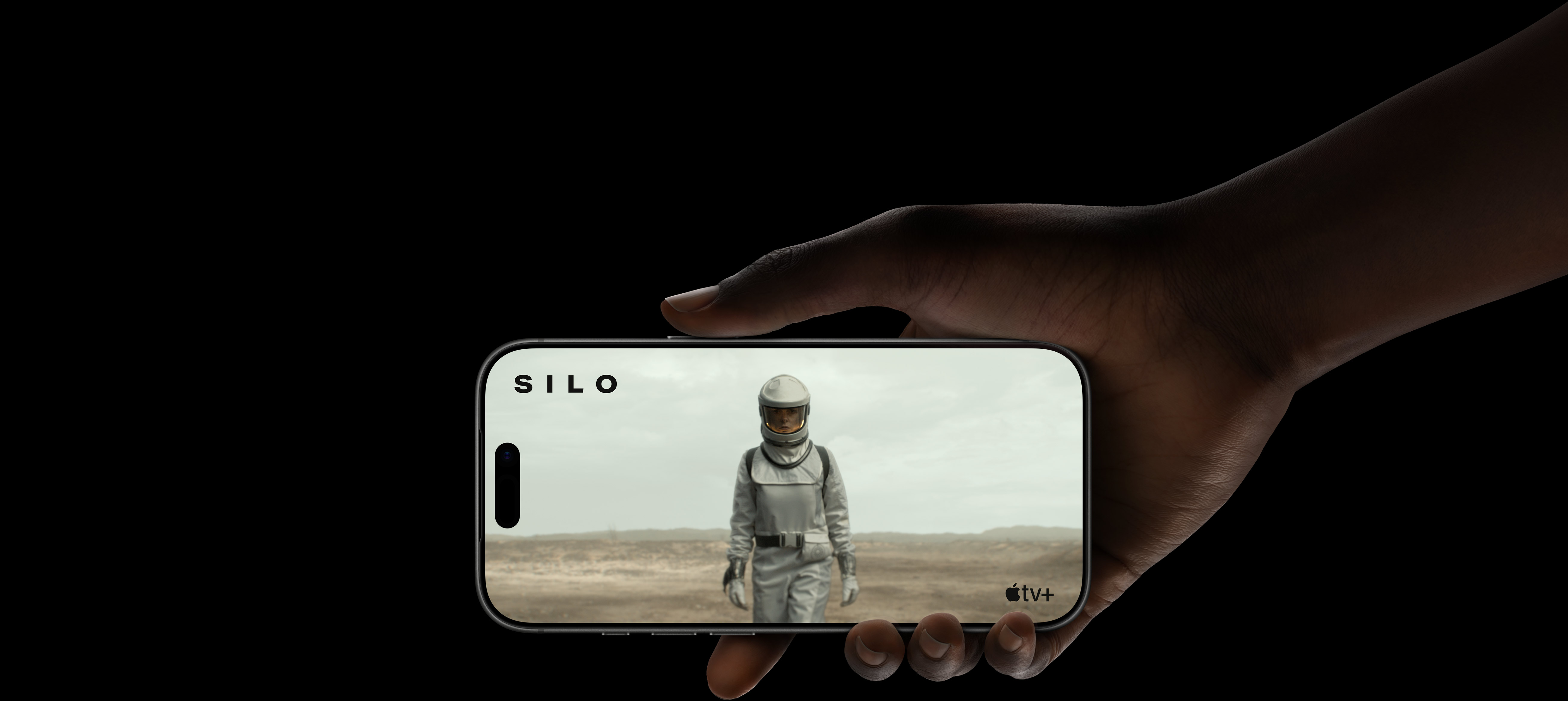 Hand holding Apple iPhone 17 Pro streaming Apple TV with astronaut displayed on full screen